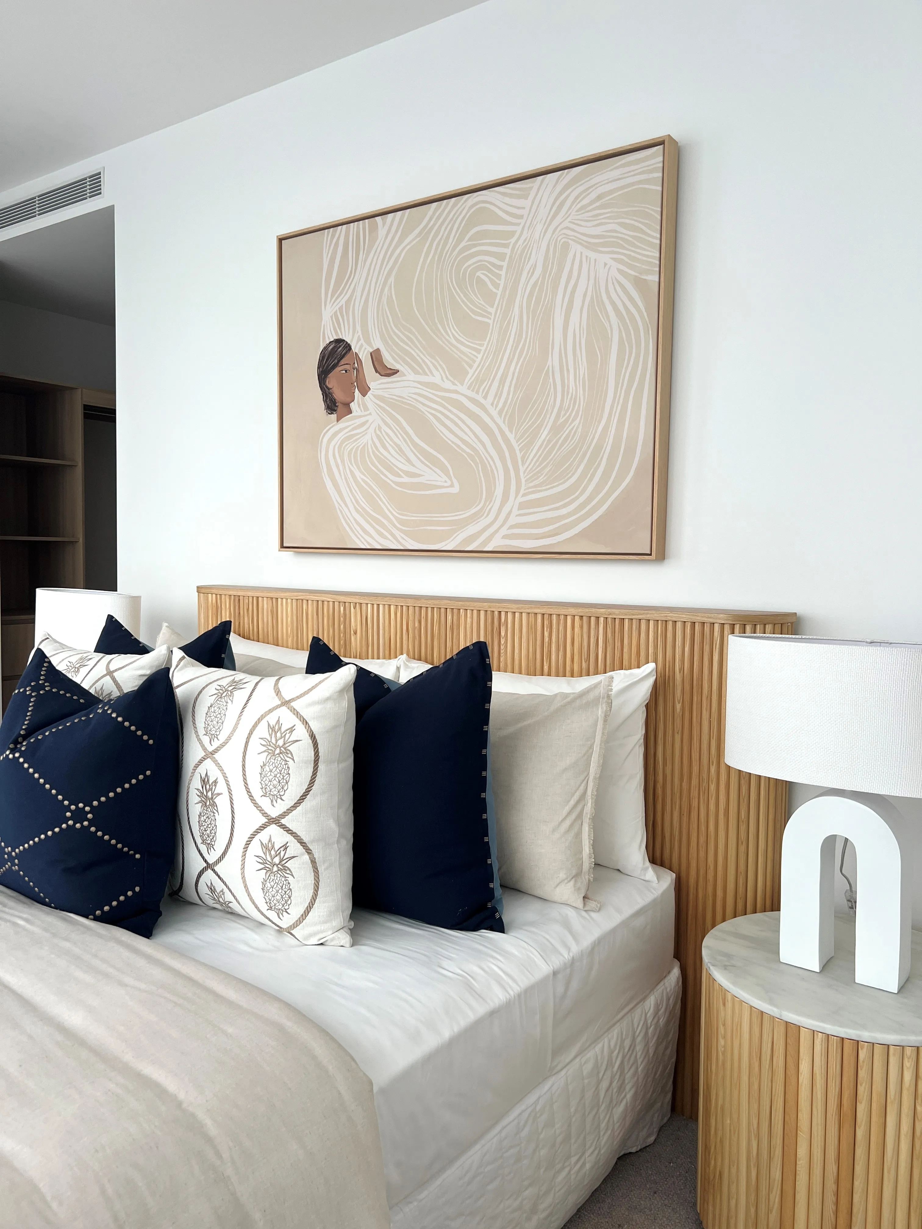 Master bedroom detail with fluted oak bedside and linen bedding